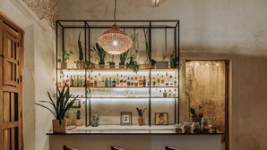 Una zona de bar con ventilador de techo, vigas de madera y suelo estampado.
