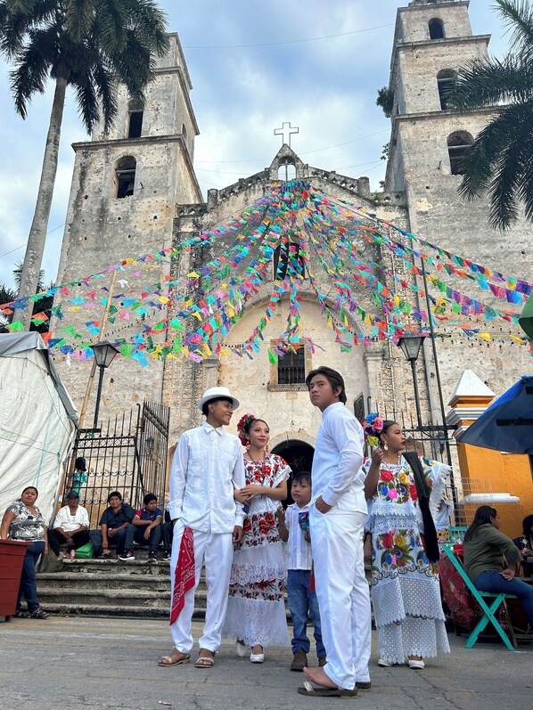 A historic church with a bell tower, decorated with colorful flags.