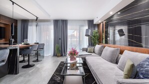 A modern living room with a sofa, coffee table, and dining area with chairs. - Appartment Val di Bora 2 (Porec)