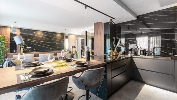 A modern kitchen with a marble countertop, integrated appliances, and a dining area with a wooden table and chairs. - Appartment Val di Bora 2 (Porec)