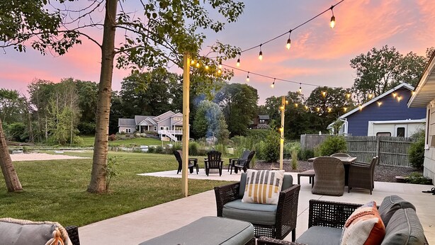 Un espace extérieur aménagé en terrasse, avec des meubles en osier et des guirlandes lumineuses.