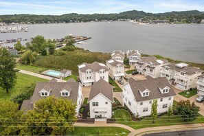 A residential area with multiple two-story houses, a swimming pool, and a marina with boats. - New Saugatuck Home: Lake Views & Walk to Town (Douglas)
