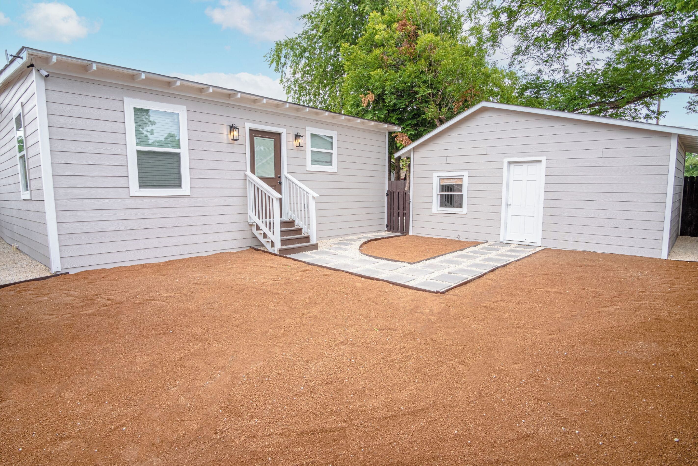 A two-story house with a covered patio and a fenced yard.