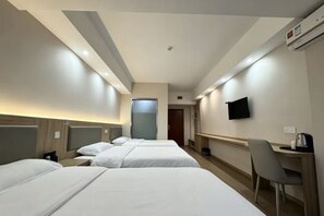 A hotel room with three beds, a desk, a chair, a television, and an air conditioning unit. - Laiyinhe Fashion Motel (Hunchun)