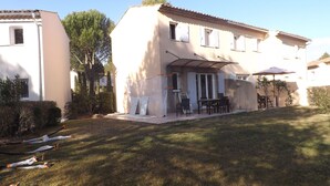 A two-story house with a covered patio area, a small garden, and a lawn. - 45 m2 house, facing the pine forest, terrace, garden and tranquillity (Mallemort)