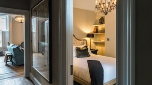 Une chambre à coucher avec un lit, une table de chevet, une lampe et un lustre.