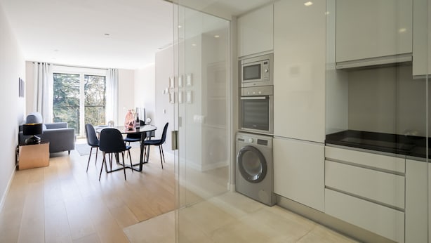 A modern kitchen with a built-in washer and dryer, a dining area with a table and chairs, and a large window providing natural light. - PALACIO REAL - MADRID, 2HH, 2 BAÑOS, 6 PAX (Madrid)