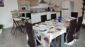 Eine kompakte Küche mit Essbereich, ausgestattet mit einer Mikrowelle, einem Herd und einem Kühlschrank.