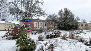 Ein Wohngebiet mit einem Haus, einem mit Schnee bedeckten Garten und einem Wegweiser.