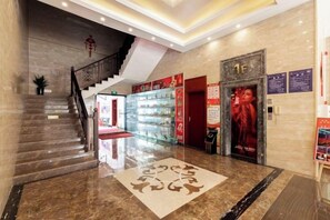 A hotel lobby with a marble floor, a staircase, a reception desk, and a glass display case. - Hedu Hotel (Dongguan Qiaotou) (Dongguan)