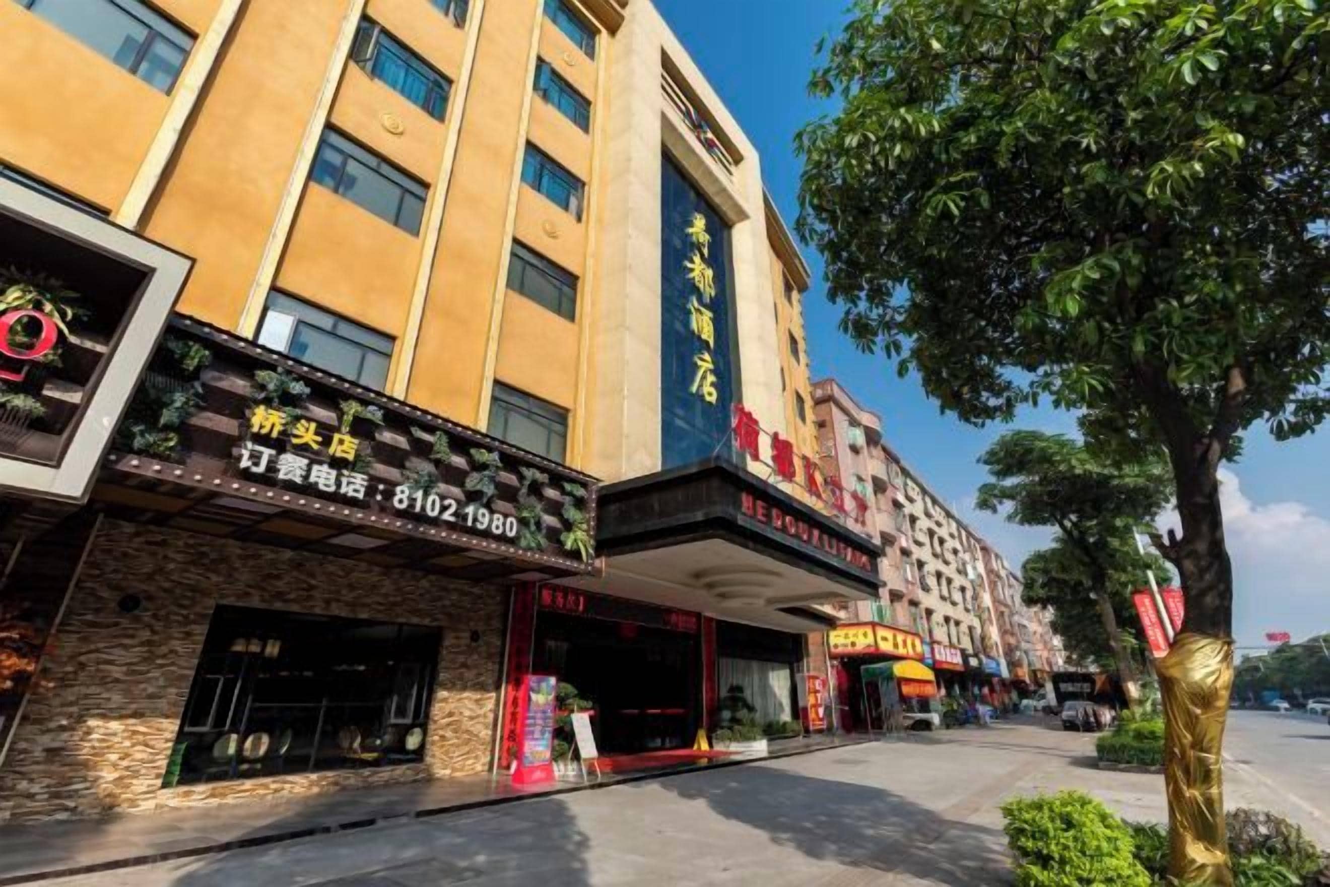 A hotel facade with multiple storefronts, including a restaurant and a cinema.