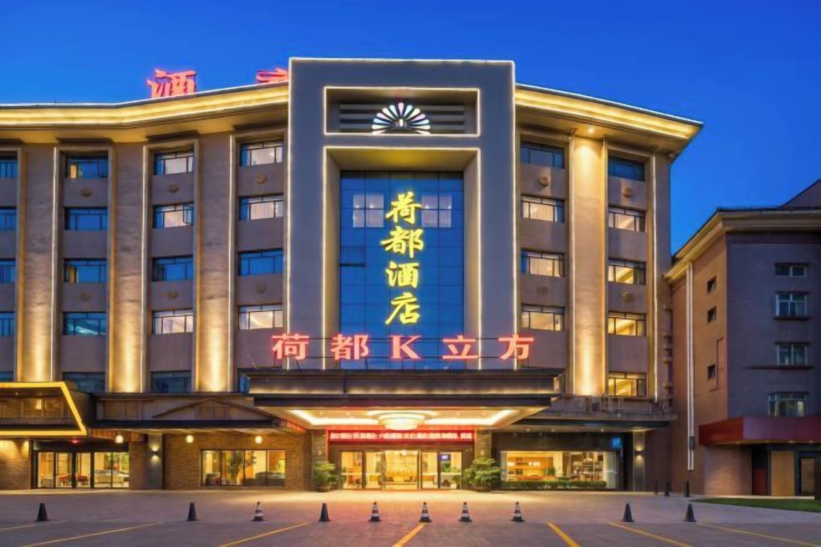 A hotel with a prominent entrance, multiple floors, and a large sign with Chinese characters.