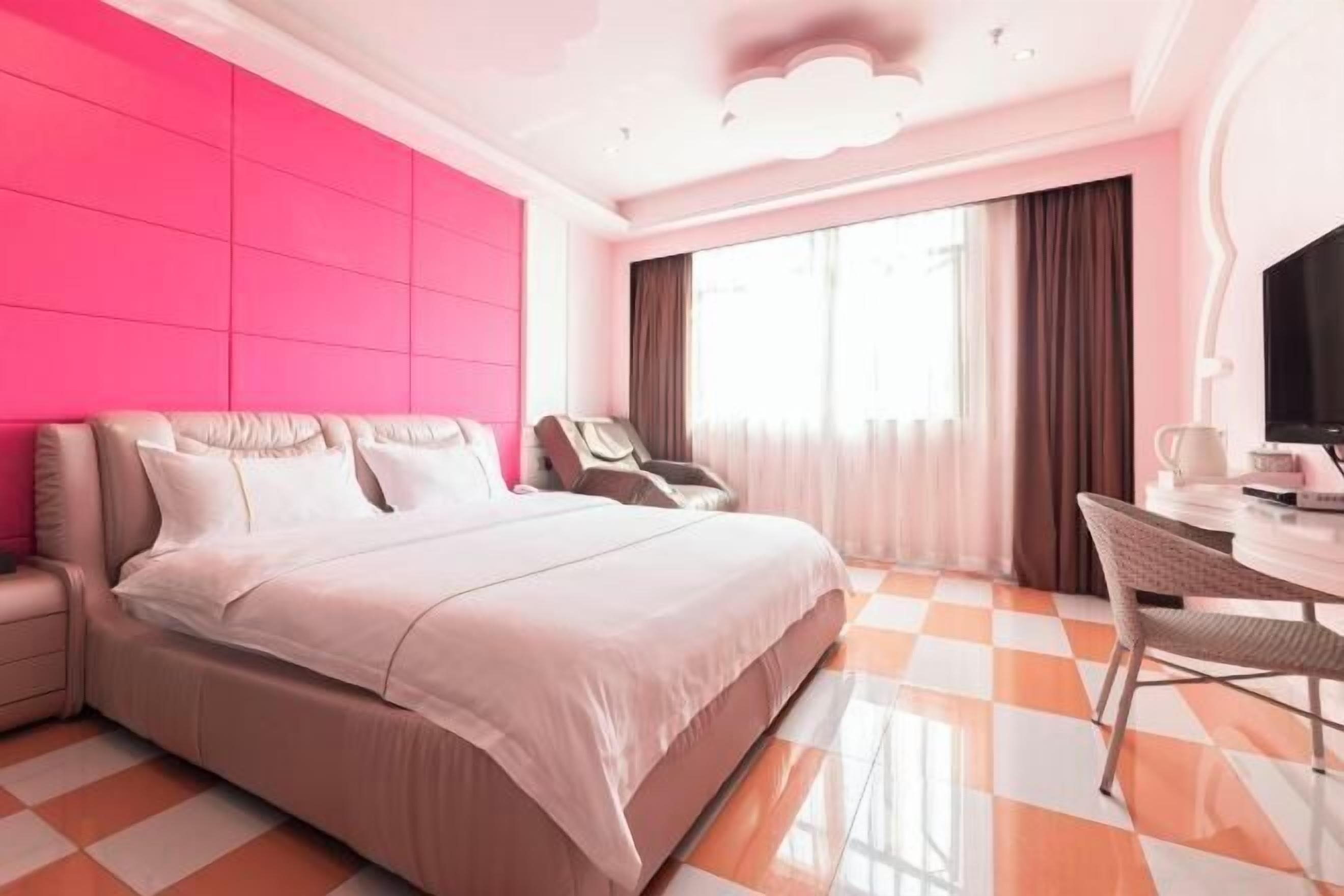 Une chambre d’hôtel moderne avec un grand lit, un bureau et une chaise.
