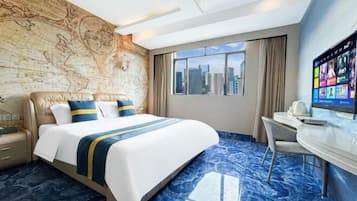 Quarto de hotel com uma cama grande, uma escrivaninha, uma televisão e vista para a cidade.