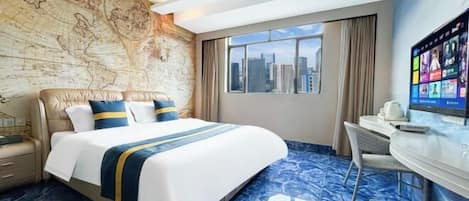 A hotel room with a large bed, a desk, a television, and a city view.