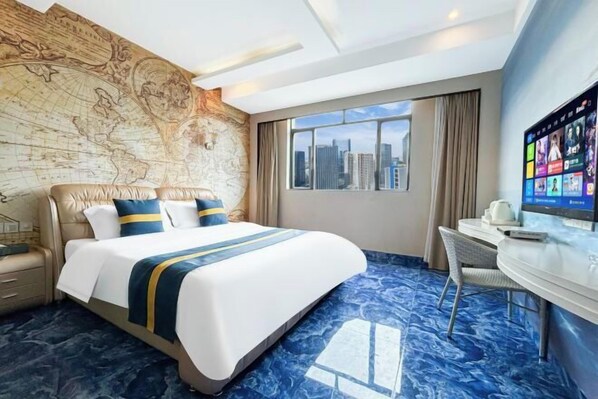 Habitación de hotel con una cama grande, escritorio, televisión y vista a la ciudad.