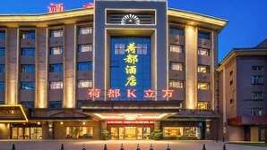 A hotel with a prominent entrance, multiple floors, and a large illuminated sign. - Hedu Hotel (Dongguan Qiaotou) (Dongguan)