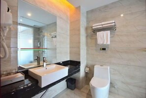 Un baño moderno con un espejo grande, un lavabo blanco, un inodoro y un toallero.
