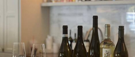 Variedad de botellas de vino y copas sobre una bandeja de madera en un bar.