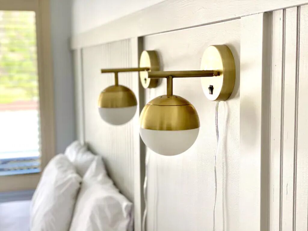 A wall-mounted light fixture with a horizontal bar and two spherical lights.