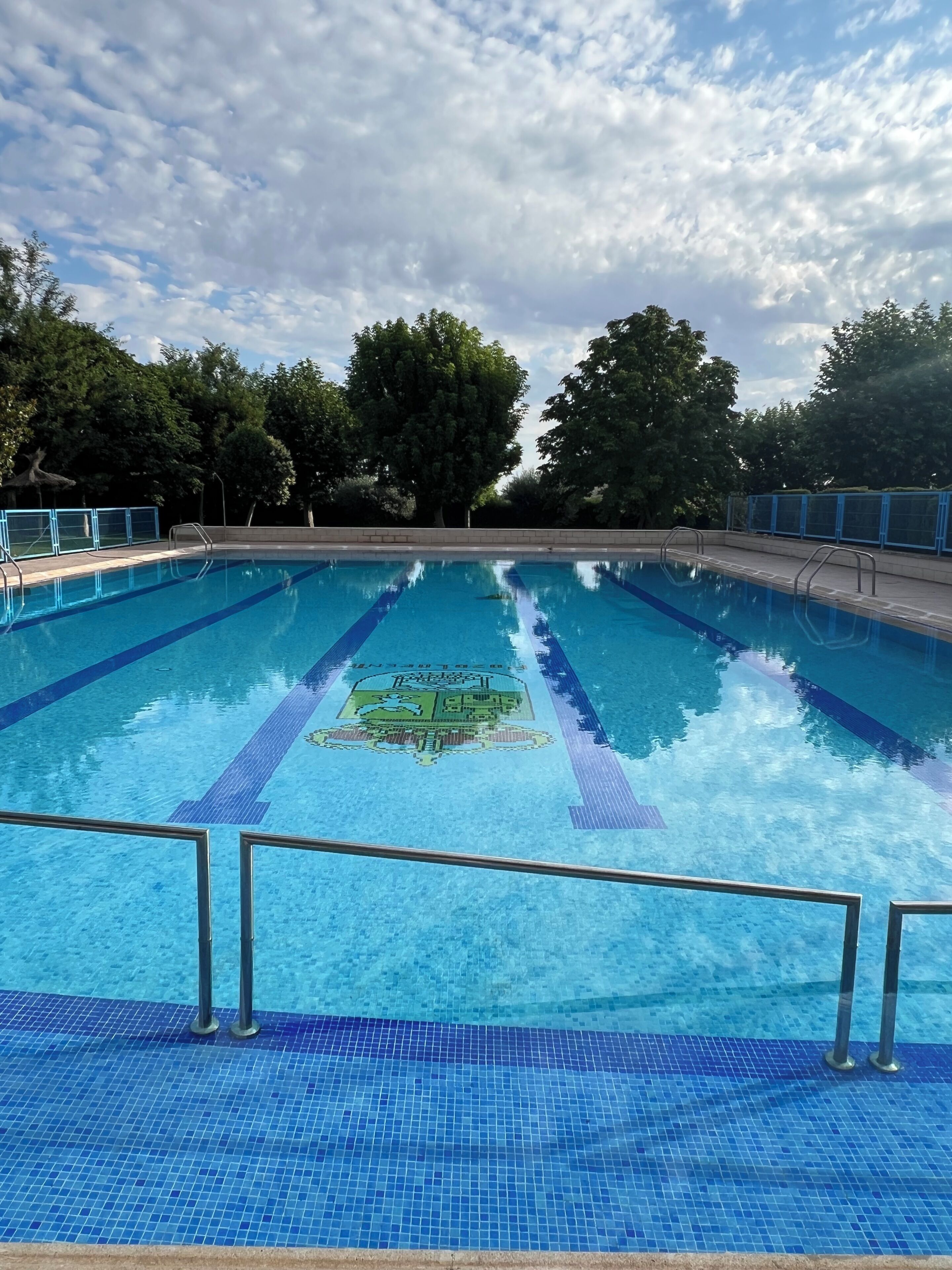 A swimming pool with lane dividers and a logo in the center.