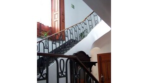 A staircase with ornate black railings and wooden doors. - Elegant Manor House near Alcalá del Jucar with Piano. (Pozo-Lorente)