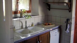 A kitchen with a double sink, a dish rack, and a window with curtains. - Elegant Manor House near Alcalá del Jucar with Piano. (Pozo-Lorente)