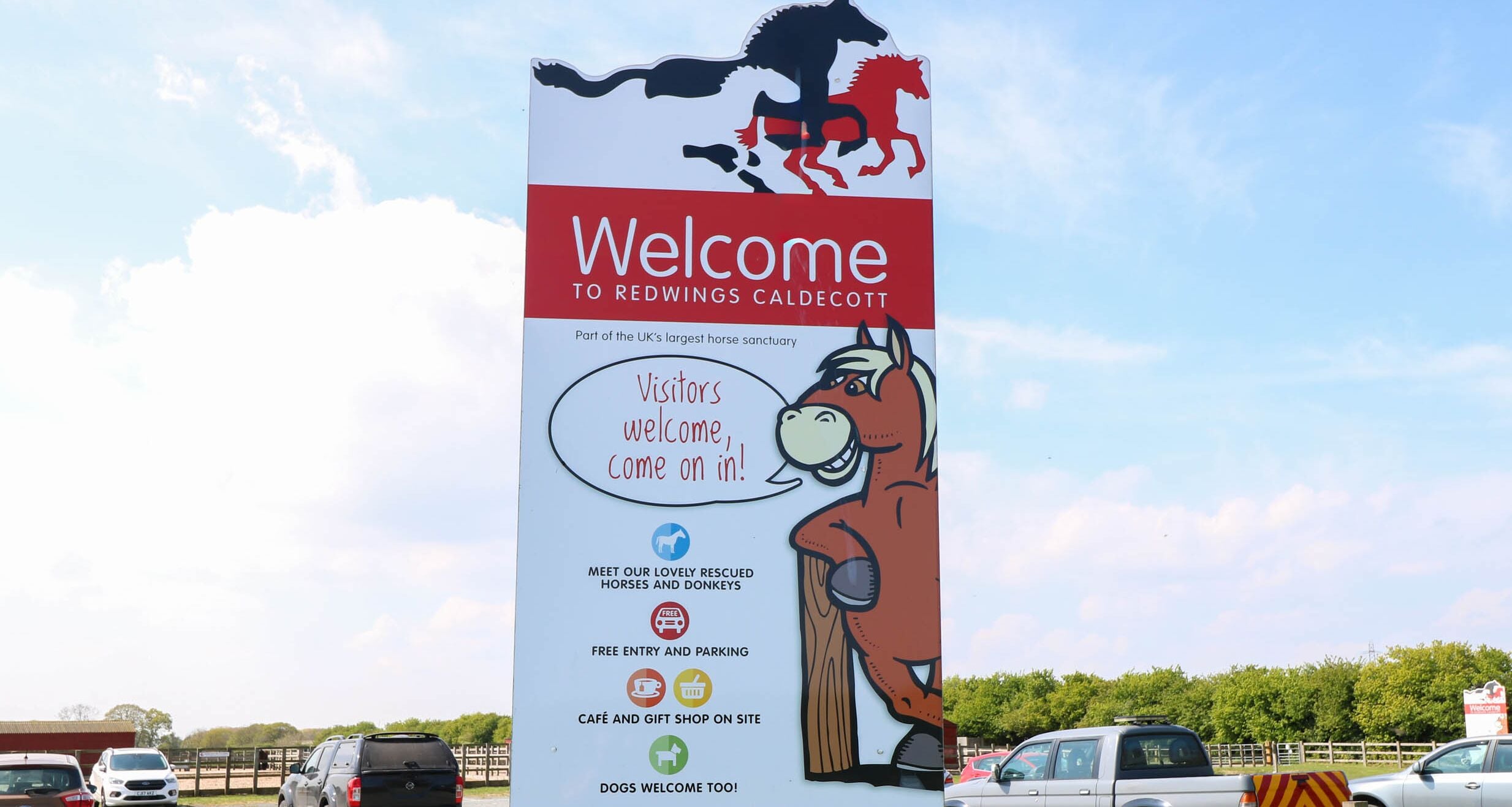 A welcome sign for Redwings Caldecott horse sanctuary with information on opening times and amenities.