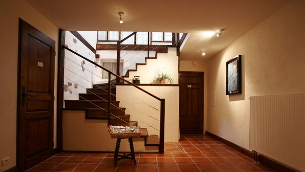 A staircase with wooden railings and a basket on the landing. - Le Clos des Pommes (Bioncourt)