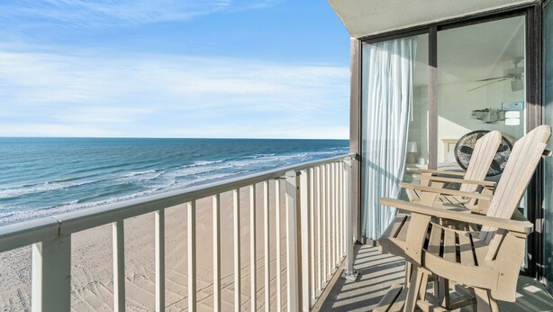 A balcony with a view of the ocean, a chair, and a fan. - Sands Beach Club II 625 - Ocean Front 2 Bed/2 Bath Condo - Amenities: Pools, Hot Tub & Tennis Court (Myrtle Beach)