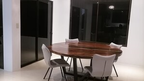 A modern dining area with a round wooden table, white chairs, and a ceiling light fixture. - Luxury Villa, 20 minutes from SJO airport , Gated community (Provincia de Alajuela)