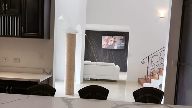 A modern kitchen with dark cabinets, a marble countertop, and a central column. - Luxury Villa, 20 minutes from SJO airport , Gated community (Provincia de Alajuela)