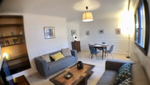 Un salon comprenant un canapé, une table basse et un coin repas avec des chaises et une table.