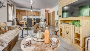 A cozy living room with a round coffee table, a sofa, and a TV cabinet. - Ground floor, terrace, tv, ski locker, 78m², Champagny-en-Vanoise (Champagny-en-Vanoise)