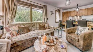 A cozy living room with a sofa, armchair, and round coffee table, featuring a scenic view through large windows. - Ground floor, terrace, tv, ski locker, 78m², Champagny-en-Vanoise (Champagny-en-Vanoise)