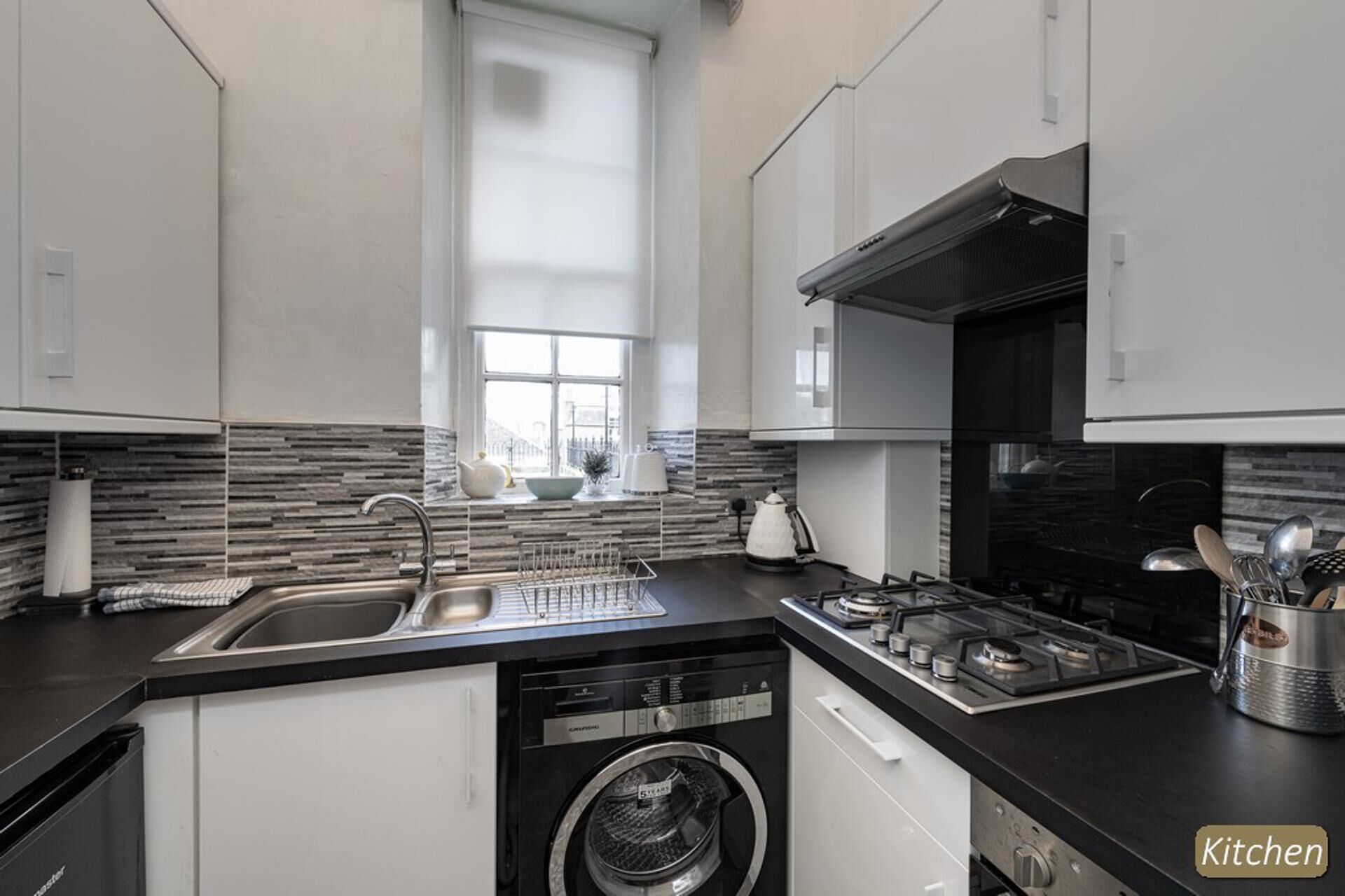 A modern kitchen with a dishwasher, stove, and sink.