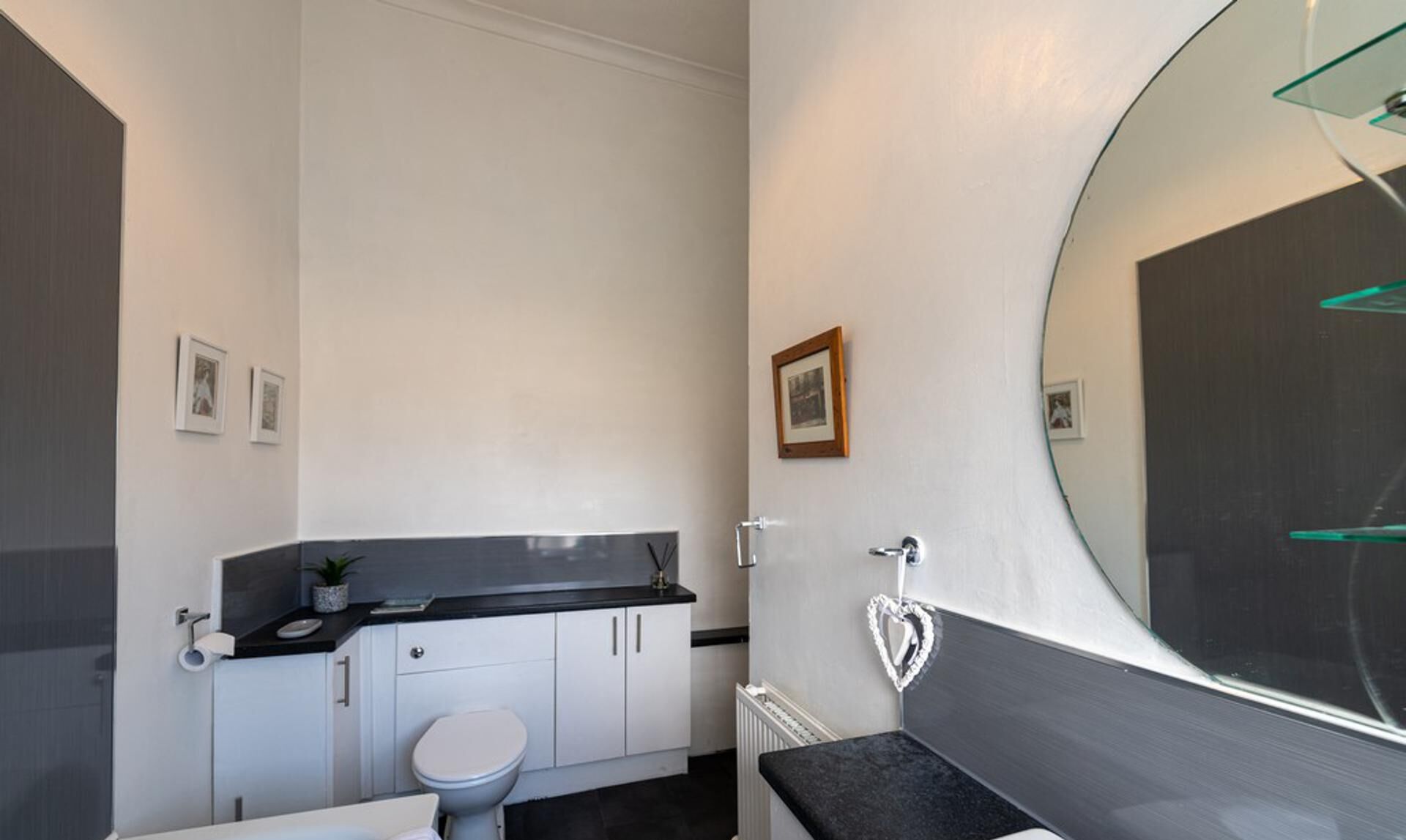 A modern bathroom with a toilet, sink, and mirror.