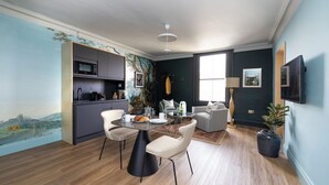 Um espaço moderno com área de refeições, cozinha e espaço para sentar.