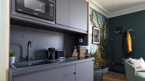 Uma cozinha moderna com armários cinza, um micro-ondas preto e uma pia.