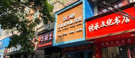 A row of storefronts with signage in a foreign language, indicating a commercial area.