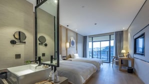 A modern hotel room with a large mirror, a white sink, two beds, a bedside table, and a view of the city through large windows. - Hongting International Hotel(Central Lake District Store) (Hangzhou)