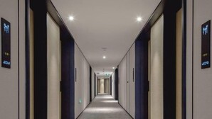 A long, narrow hallway with doors on both sides, each marked with a number. - Hongting International Hotel(Central Lake District Store) (Hangzhou)
