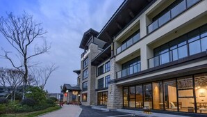 A multi-story hotel with a modern architectural design, featuring large windows and a stone facade. - Hongting International Hotel(Central Lake District Store) (Hangzhou)
