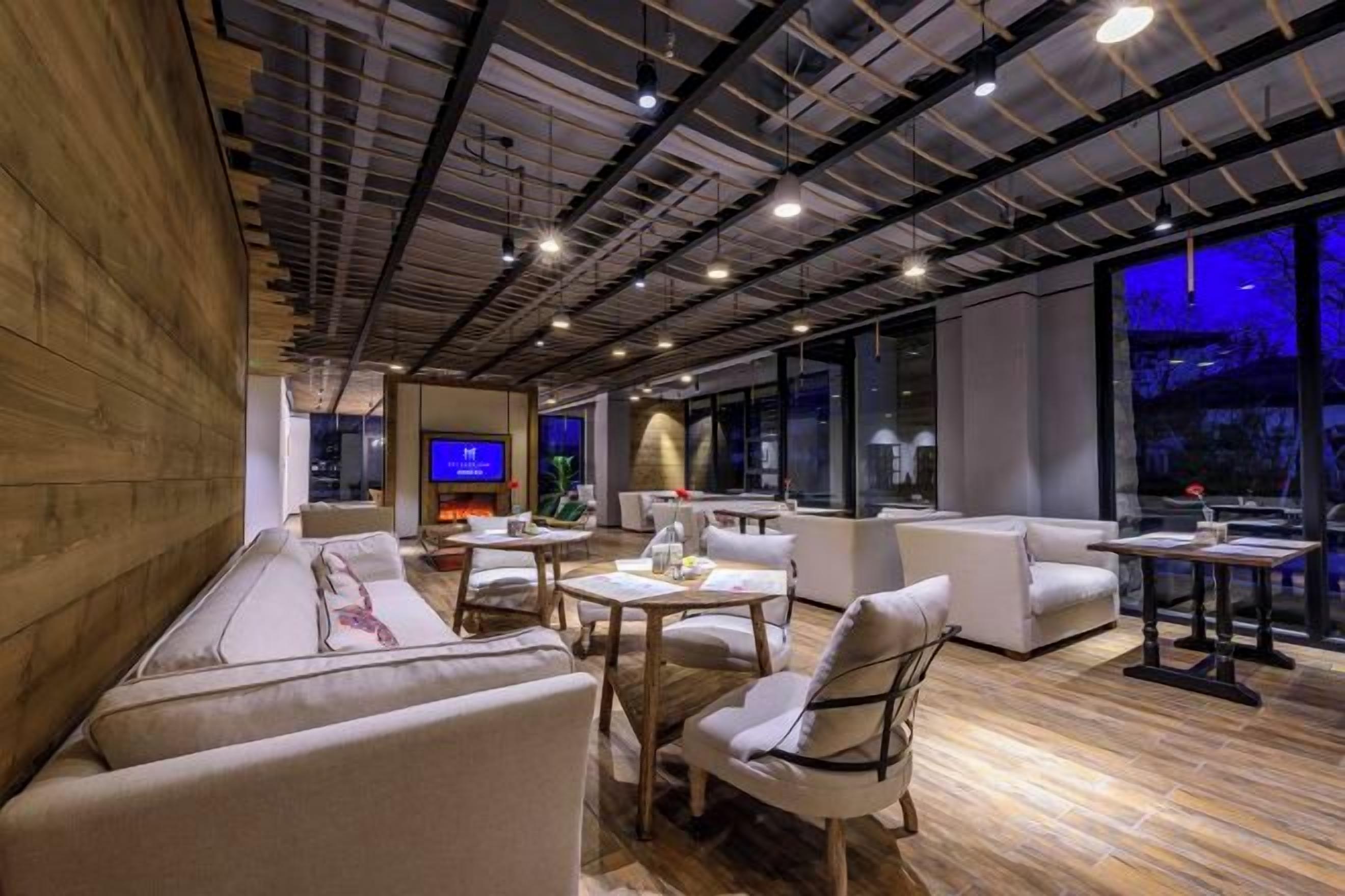 Un interior moderno con techo de madera, un sofá, una mesa y un televisor.