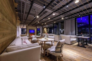 Un interior moderno con techo de madera, un sofá, una mesa y un televisor.