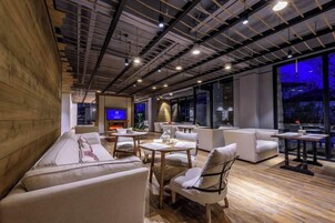 Un interior moderno con techo de madera, un sofá, una mesa y un televisor.