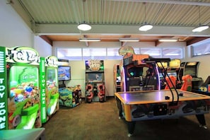 Una habitación con máquinas de arcade, un juke-box y una zona de juegos.