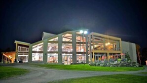 Een modern gebouw met grote glasramen en een goed verlichte ingang.