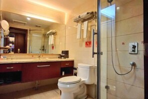 A modern bathroom with a glass shower enclosure, a white toilet, and a vanity with a mirror. - Xingkai Garden Hotel (Panzhou)