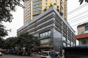 Un immeuble à étages doté d’une architecture moderne, caractérisé par une entrée imposante et une enseigne bien visible.